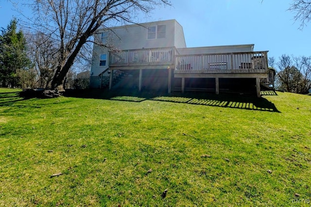rear view of house with stairs, a deck, and a lawn