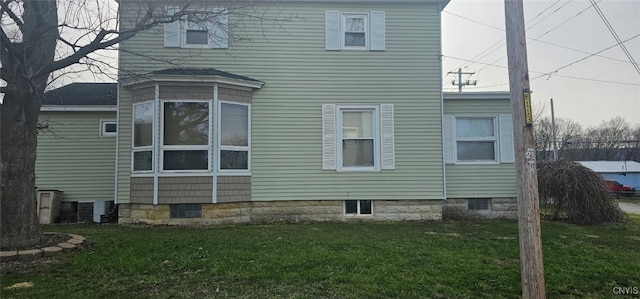 back of house featuring central AC and a yard