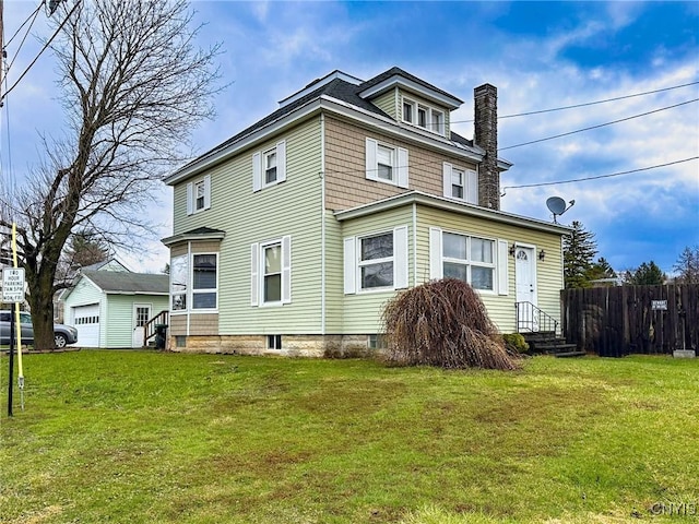 rear view of property featuring a yard, a chimney, fence, and entry steps