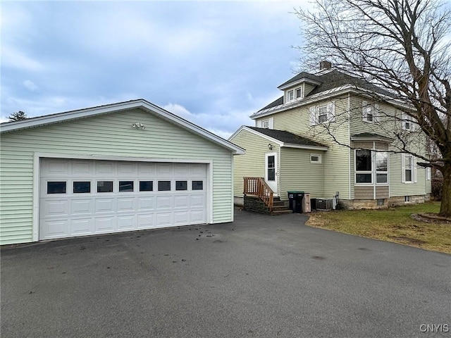 exterior space featuring an outdoor structure, central air condition unit, and a detached garage