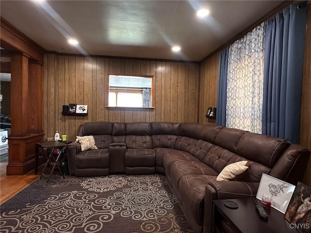 living area featuring ornate columns, wood finished floors, and wooden walls