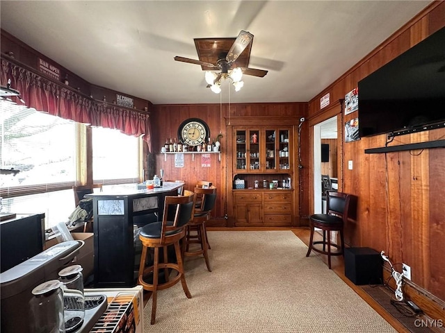dining room with wood walls and a ceiling fan