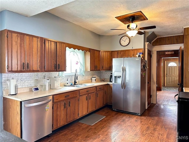 kitchen featuring light countertops, a sink, ceiling fan, appliances with stainless steel finishes, and brown cabinets