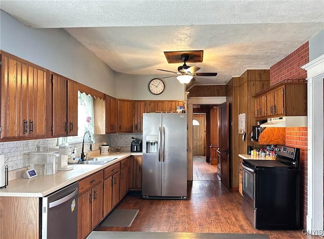 kitchen featuring ceiling fan, a sink, stainless steel appliances, and brown cabinets