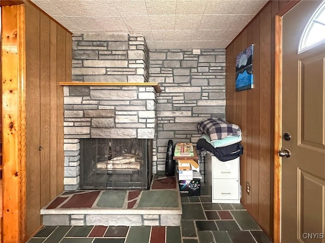 interior details featuring a fireplace and wood walls