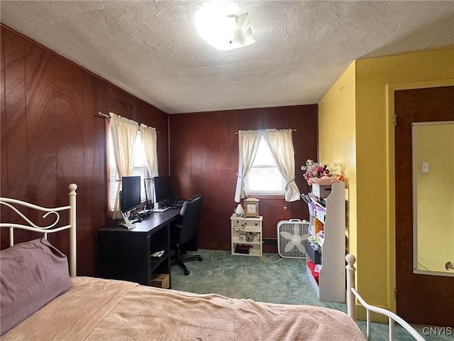 bedroom with carpet floors, wood walls, and a textured ceiling