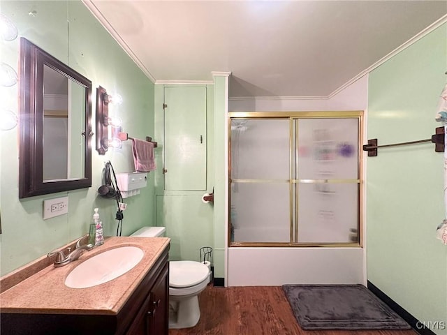full bathroom with toilet, vanity, wood finished floors, enclosed tub / shower combo, and ornamental molding