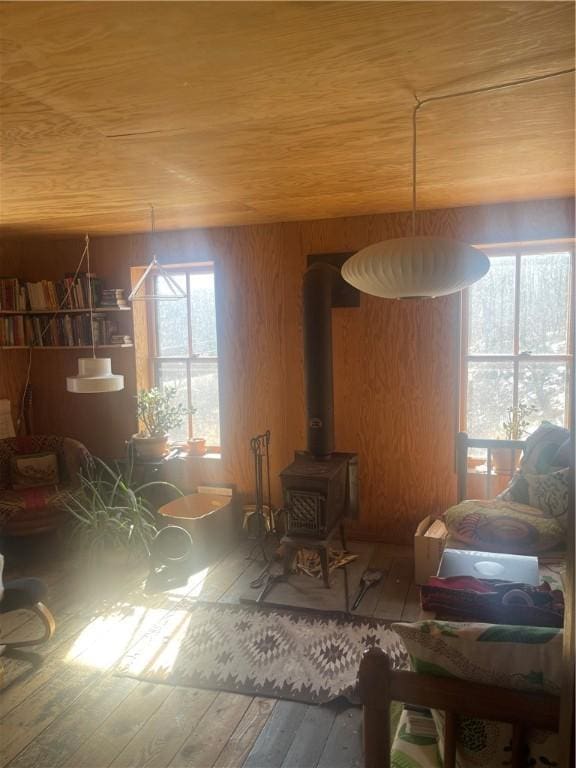 living room with a wood stove, wood ceiling, and wood-type flooring