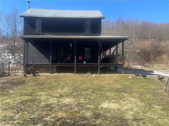 view of front facade with metal roof and a front lawn
