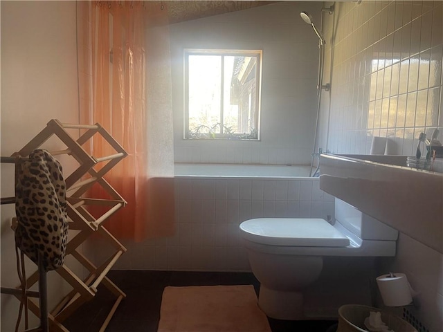 full bath with toilet, tiled shower / bath, and lofted ceiling