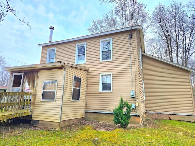 back of house with a lawn and a deck