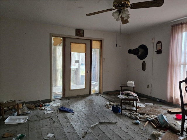 interior space featuring hardwood / wood-style floors, a ceiling fan, and baseboards