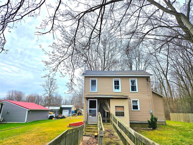 back of property featuring a lawn and fence