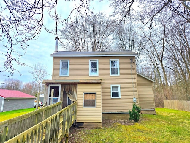 rear view of property with fence and a yard