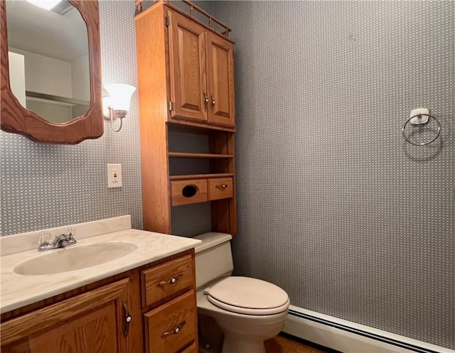 bathroom with vanity, toilet, and baseboard heating