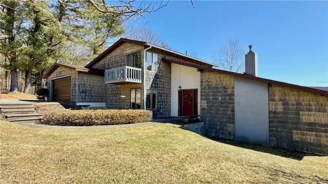 view of front of house featuring a balcony, a front yard, a garage, and a chimney