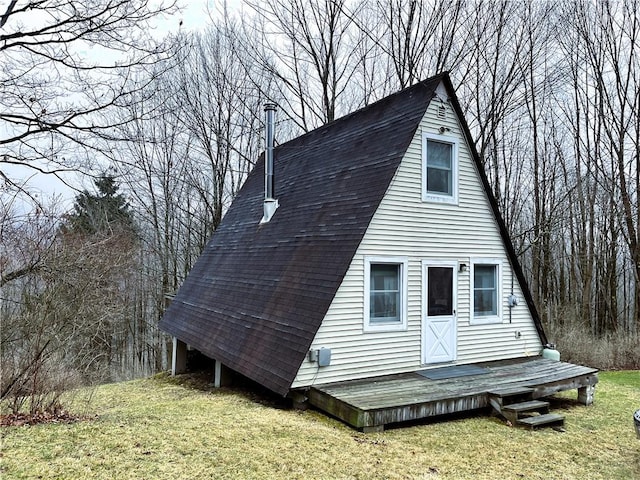 exterior space with a wooden deck, a lawn, and roof with shingles