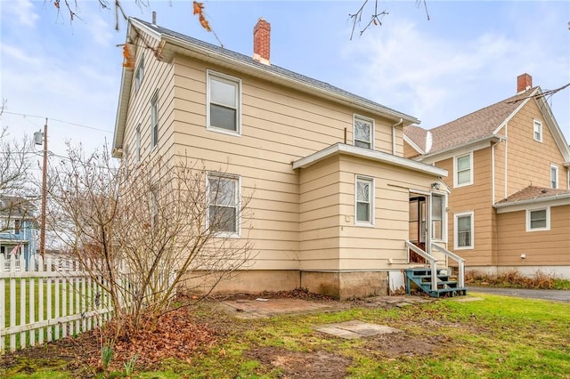 179 S W St, Geneva-City, NY 14456 - rear view of property featuring a yard, a chimney, fence, and entry steps