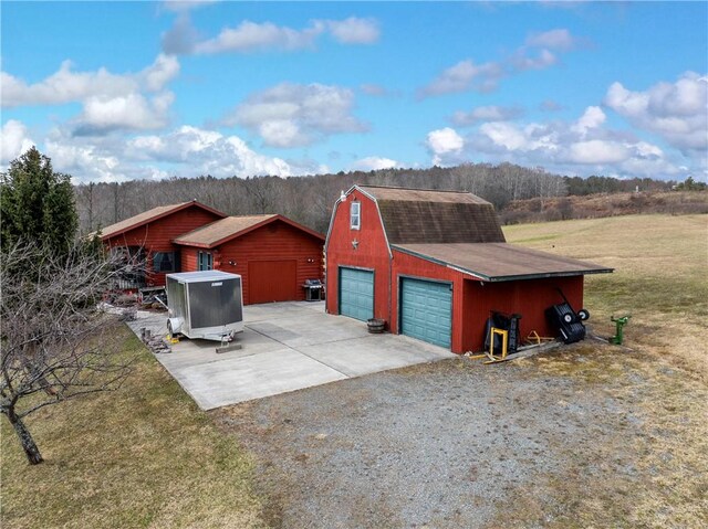 7061 Velie Rd, Bath, NY 14879 - detached garage featuring driveway and a forest view