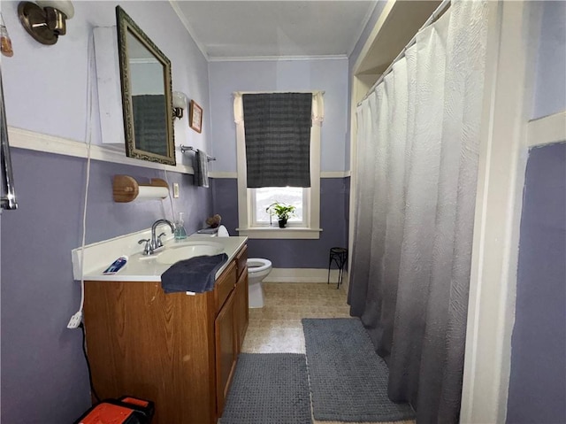 bathroom with toilet, vanity, a shower with curtain, baseboards, and ornamental molding