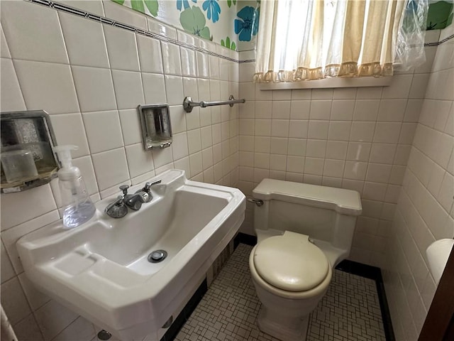 174 N Bennett St, Bradford-City, PA 16701 - bathroom featuring tile walls, toilet, a sink, and tile patterned floors