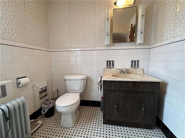 174 N Bennett St, Bradford-City, PA 16701 - bathroom featuring radiator heating unit, wallpapered walls, tile walls, wainscoting, and toilet