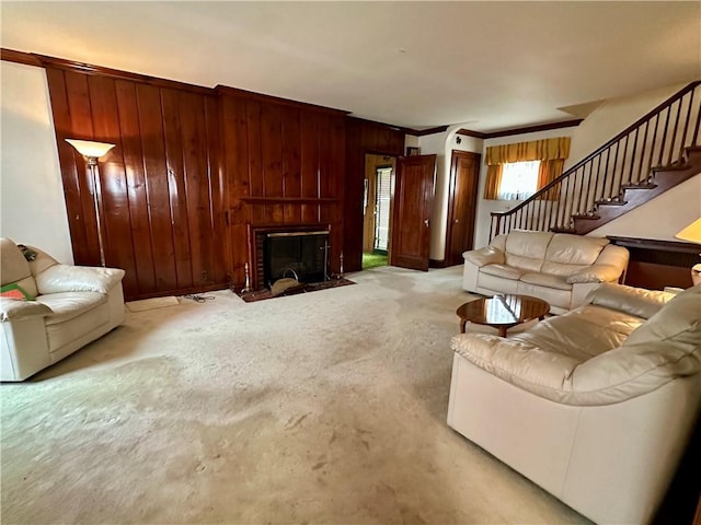 174 N Bennett St, Bradford-City, PA 16701 - living room featuring wood walls, a fireplace with flush hearth, ornamental molding, stairs, and carpet