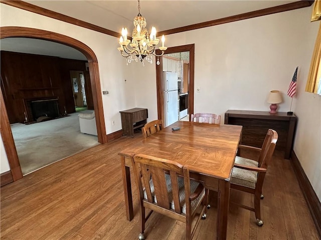 174 N Bennett St, Bradford-City, PA 16701 - dining area featuring arched walkways, a chandelier, wood finished floors, baseboards, and crown molding