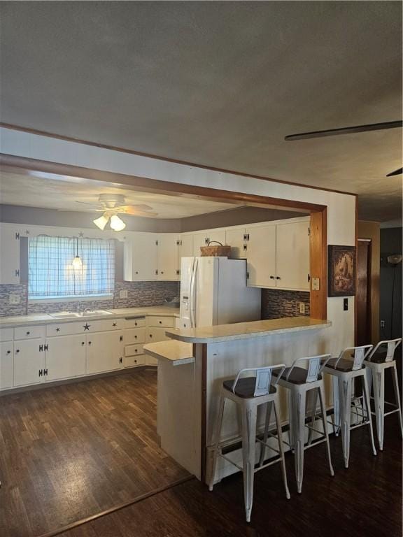 305 State St, Smethport-Borough, PA 16749 - kitchen with tasteful backsplash, dark wood-type flooring, white cabinets, a peninsula, and white fridge with ice dispenser