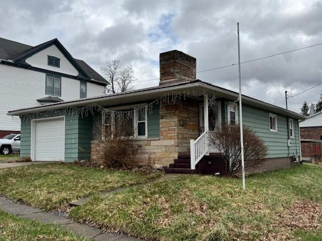 305 State St, Smethport-Borough, PA 16749 - view of front facade featuring stone siding, a front yard, a garage, and a chimney