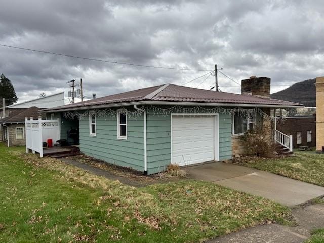 305 State St, Smethport-Borough, PA 16749 - back of house with a chimney, a garage, concrete driveway, and a yard