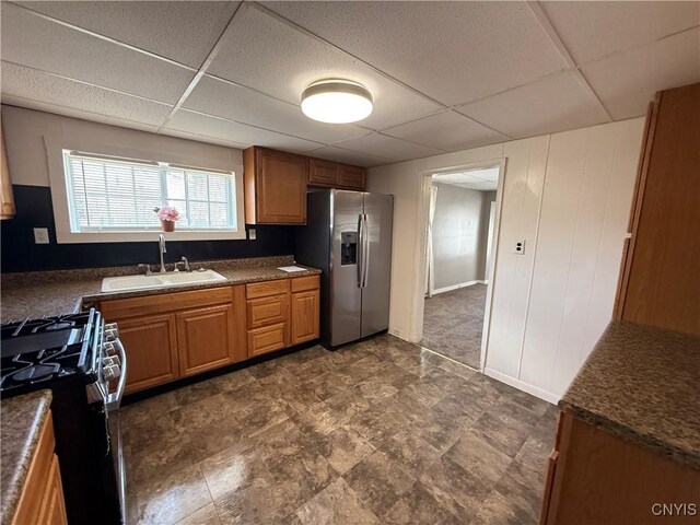 318 Academy St, Watertown-City, NY 13601 - kitchen featuring stainless steel fridge, a sink, range with gas stovetop, a drop ceiling, and dark countertops