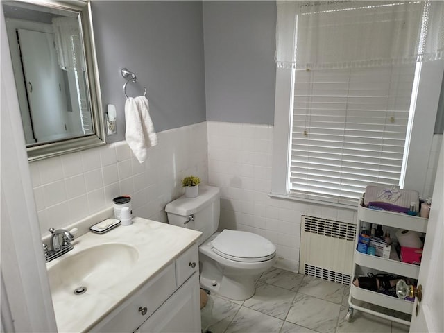 114 Country Club Dr, Elmira, NY 14905 - bathroom featuring toilet, vanity, radiator, marble finish floor, and tile walls