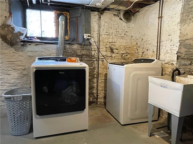 washroom featuring a sink, laundry area, and washer and clothes dryer