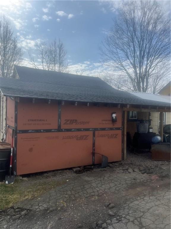 view of side of property with roof with shingles