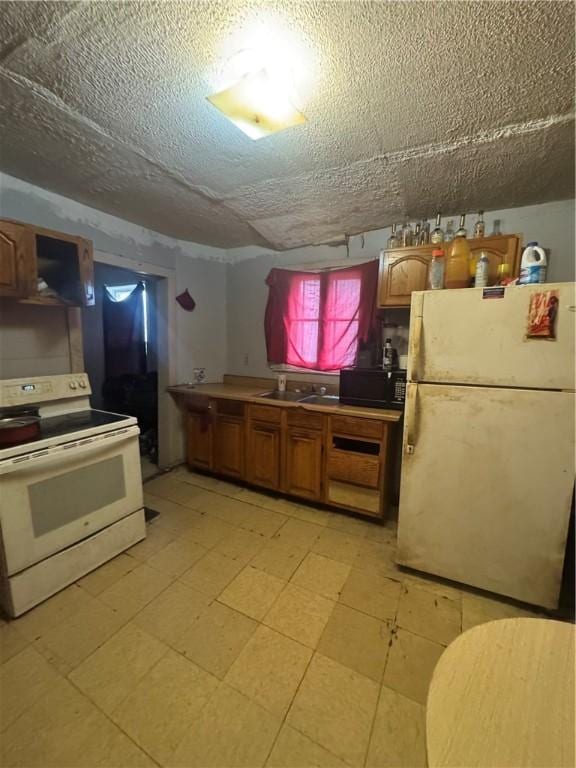 659 Bay St, Rochester, NY 14609 - kitchen with a sink, a textured ceiling, brown cabinetry, and white appliances