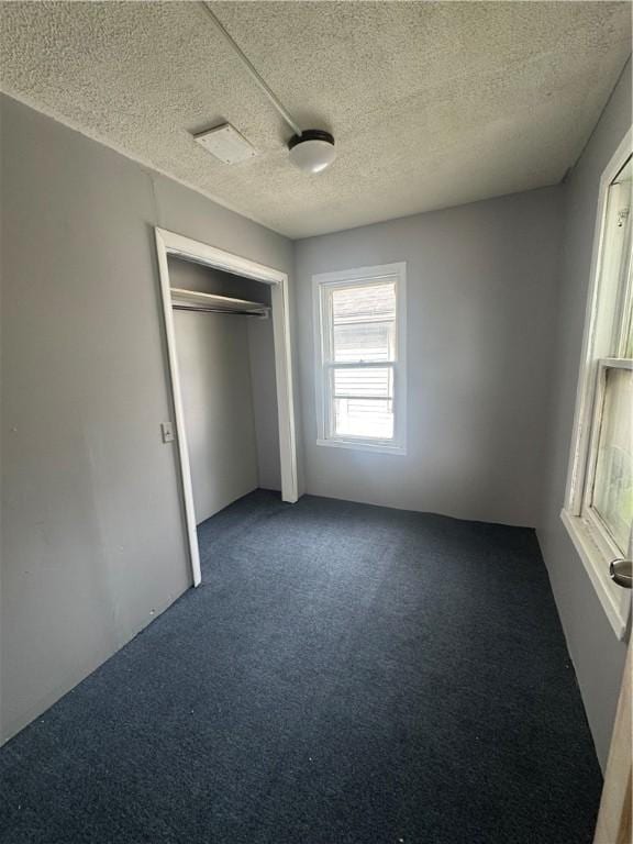 659 Bay St, Rochester, NY 14609 - unfurnished bedroom featuring a closet, carpet floors, a textured ceiling, and visible vents