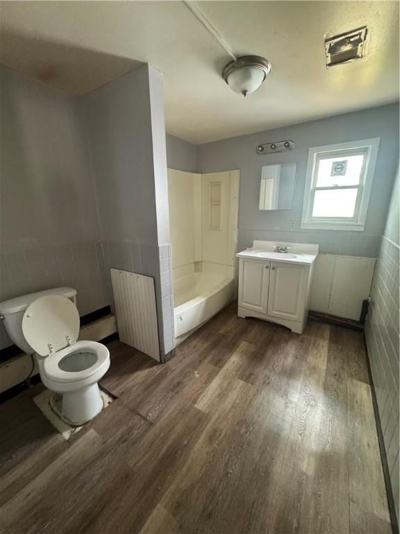 659 Bay St, Rochester, NY 14609 - bathroom featuring vanity, tile walls, toilet, walk in shower, and wood finished floors