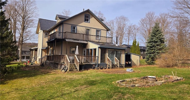 rear view of house with a balcony and a lawn
