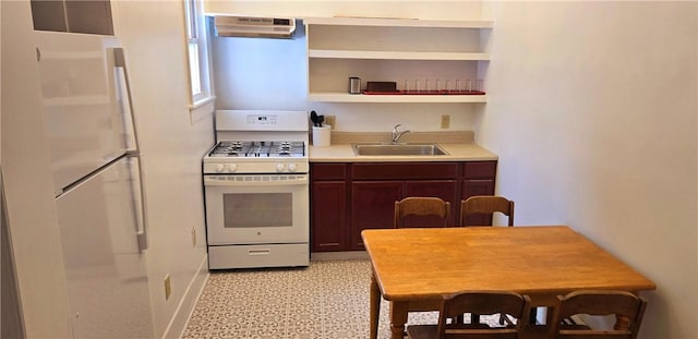 kitchen with light countertops, white appliances, under cabinet range hood, a sink, and open shelves