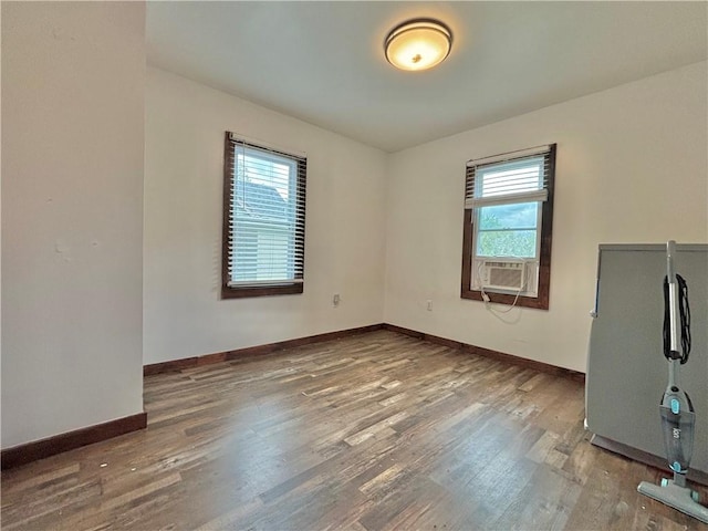 717 Spaulding St, Elmira-City, NY 14904 - spare room with plenty of natural light, wood finished floors, cooling unit, and baseboards