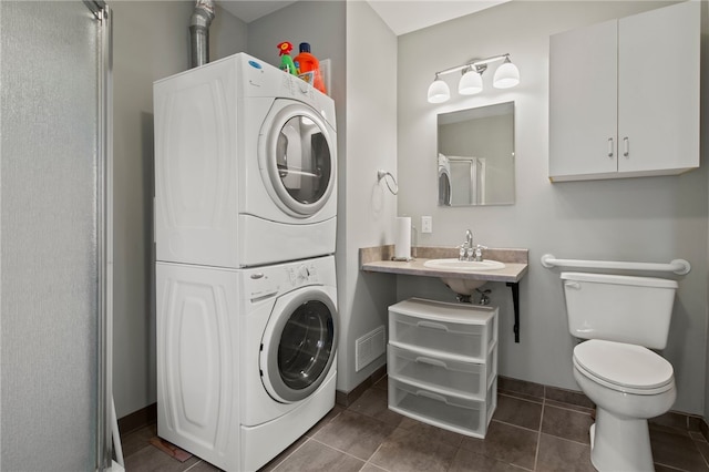 280 S Main St, Canandaigua-City, NY 14424 - bathroom featuring stacked washer / dryer, baseboards, toilet, tile patterned floors, and a sink
