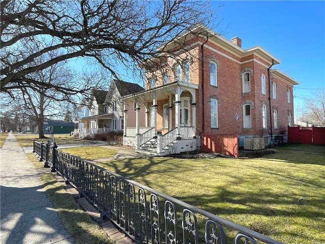 280 S Main St, Canandaigua-City, NY 14424 - view of home's exterior featuring brick siding, a fenced front yard, a yard, and a chimney