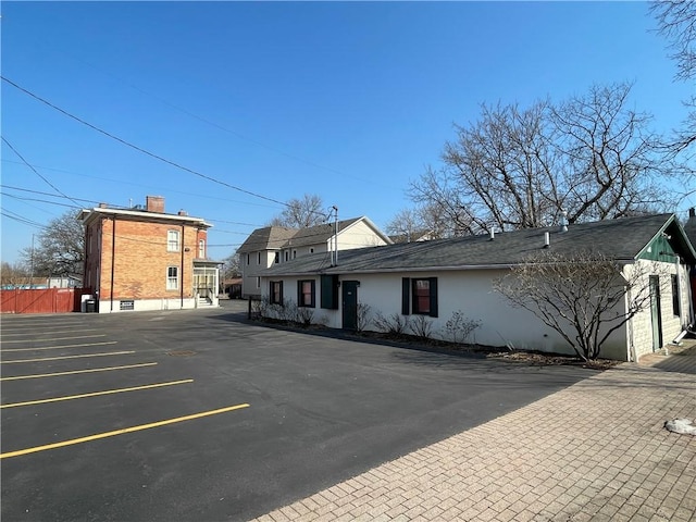 280 S Main St, Canandaigua-City, NY 14424 - exterior space featuring fence, stucco siding, and uncovered parking