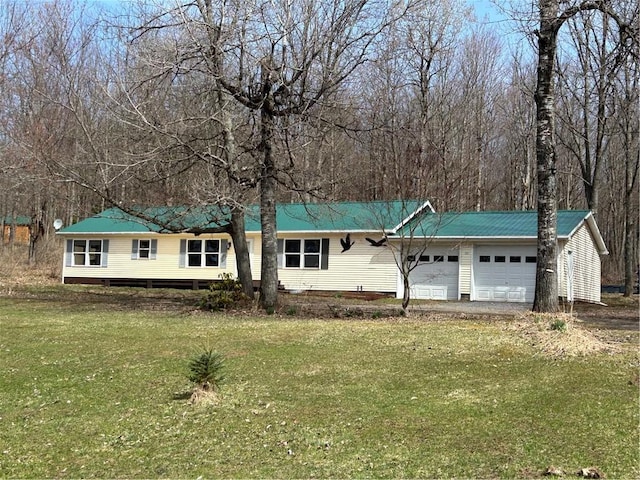 ranch-style house featuring an attached garage, metal roof, and a front lawn