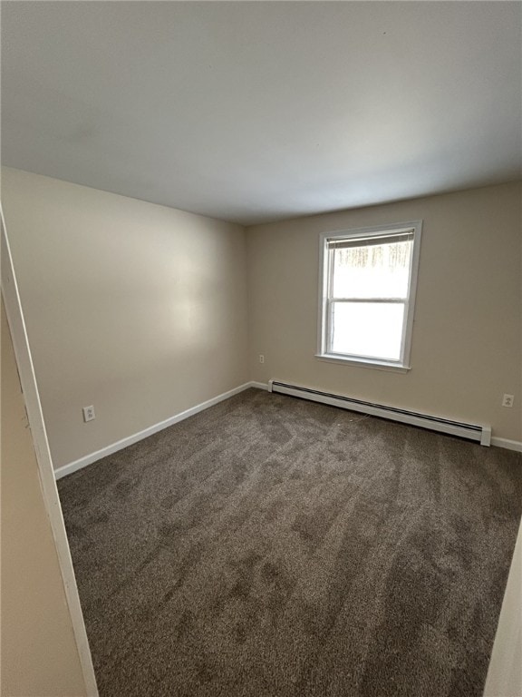 unfurnished room with a baseboard radiator, baseboards, and dark colored carpet