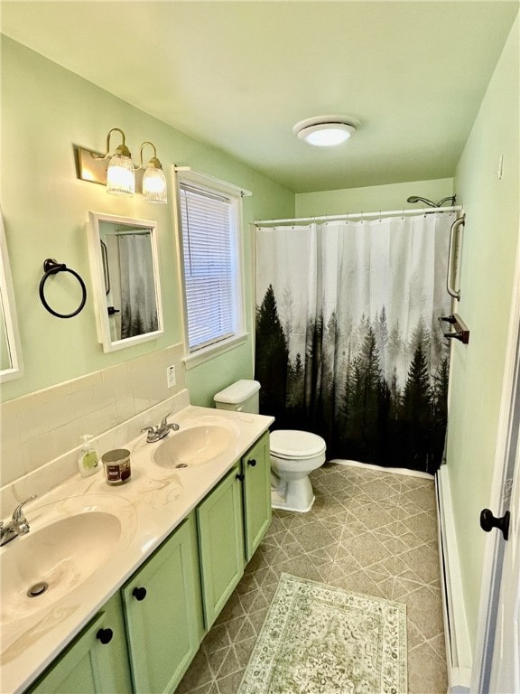 full bath with double vanity, a sink, toilet, and curtained shower
