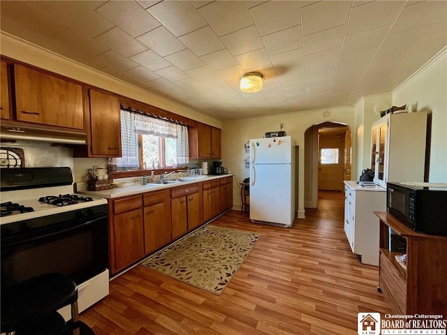 546 S Roberts Rd, Dunkirk-City, NY 14048 - kitchen featuring gas range oven, under cabinet range hood, arched walkways, freestanding refrigerator, and black microwave