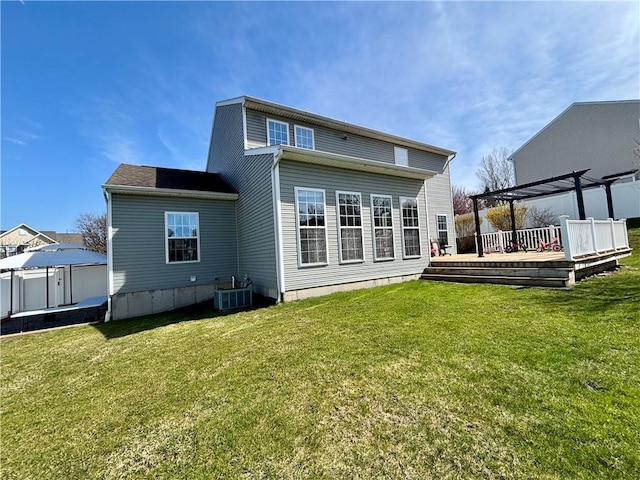 rear view of property featuring a yard, central AC unit, a deck, and a pergola