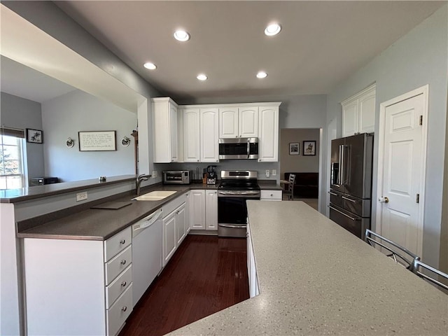 kitchen featuring white cabinetry, a sink, stainless steel appliances, and recessed lighting